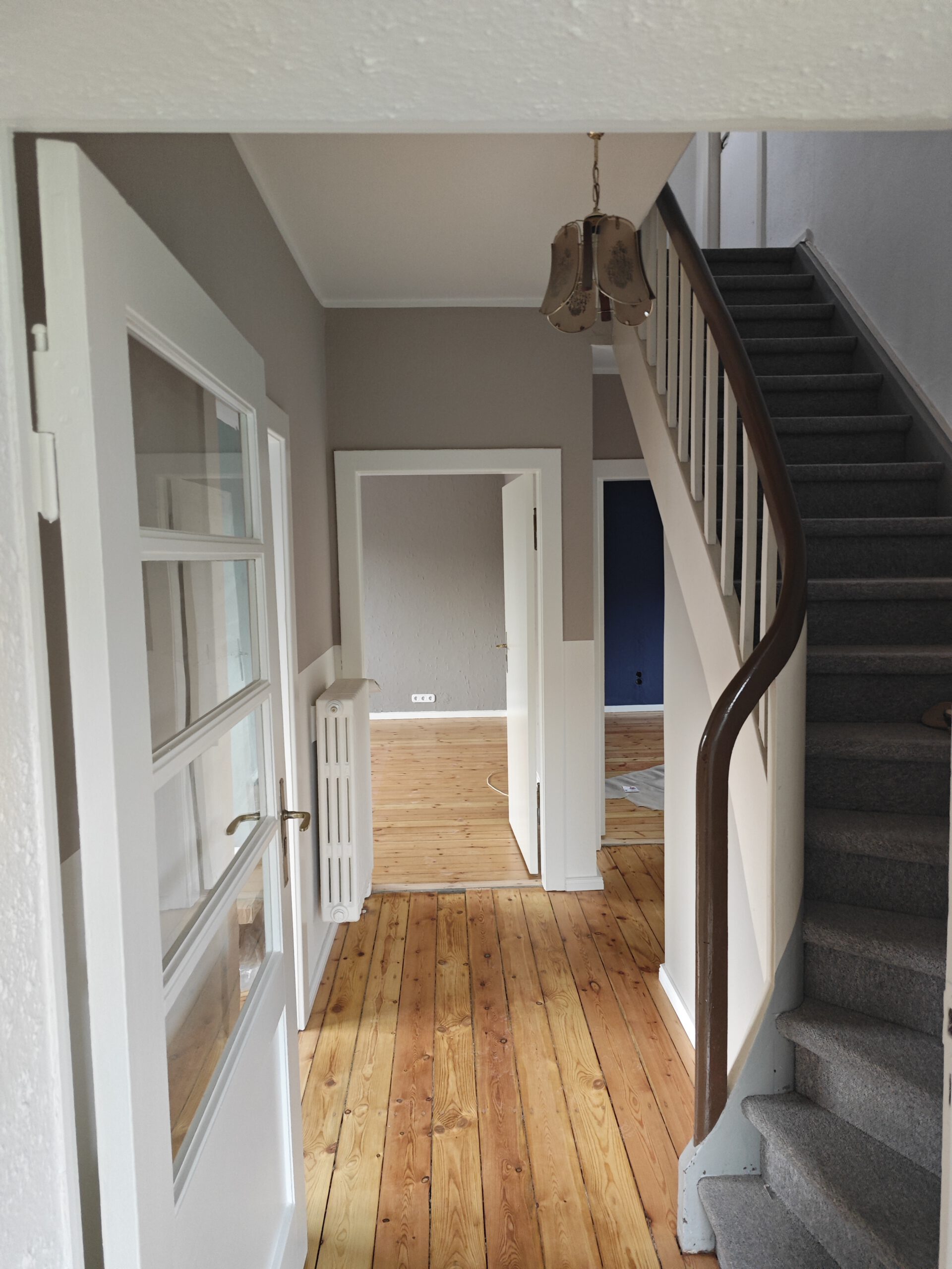 Renovierter Flur mit Treppe und Holzboden in einem Altbau